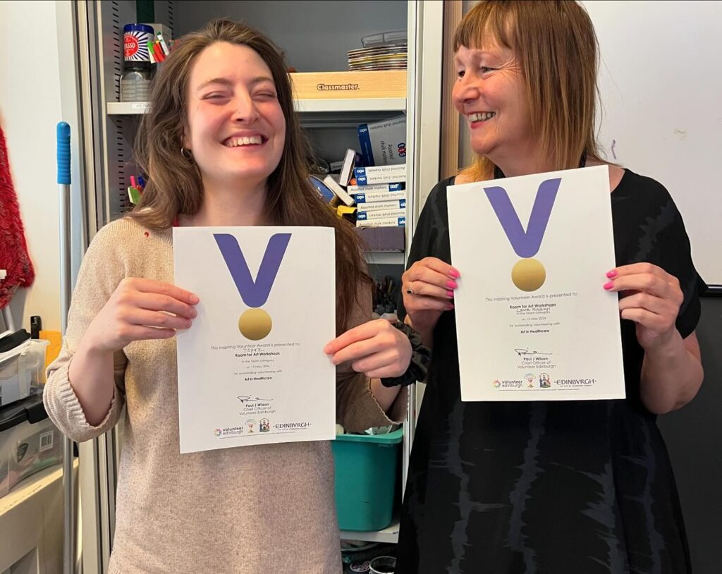 Two of our volunteers holding their certificates and smiling