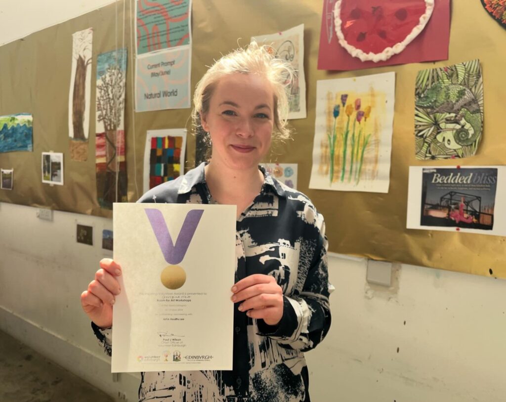 One of our volunteers holding her certificate and smiling